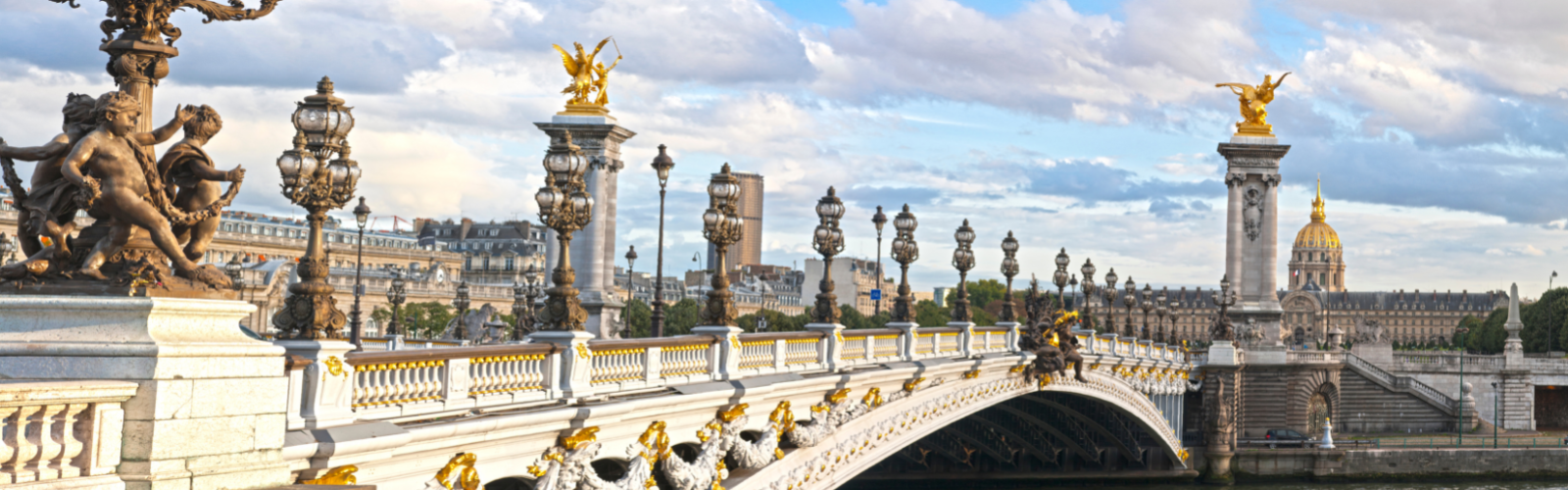 Ornate bridge over the Seine river. It has gold decals along the lower arch and lampposts lining the residential path.